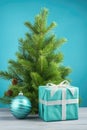 Gift box with fir tree on color background