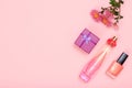 Gift box, flowers, bottle of perfume and bottle with nail polish on a pink background. Women cosmetics and accessories.