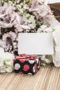 Gift box and flowers with an empty tag Royalty Free Stock Photo