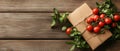 Gift box with fresh tomatoes and basil on rustic wood surface, farm fresh produce. Royalty Free Stock Photo