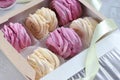 Gift box full of black currant and banana marshmallow. Close up view of creamy pale yellow and violet zefir on the grey
