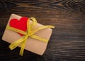 Gift box with Golden ribbon and red heart on wooden texture dark Royalty Free Stock Photo