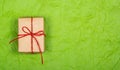 Gift box on a green background. Simple gift wrapping. Recycled paper.