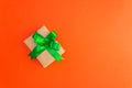 Gift box with a green bow on an orange background Royalty Free Stock Photo