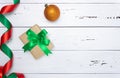 Gift box with a green bow and satin ribbon on a white wooden background, Christmas ball. Free space for text, top view. New year, Royalty Free Stock Photo