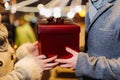 Gift box in the hands of a man and a woman against the background of Christmas street lights. Romantic date Loving couple on Royalty Free Stock Photo