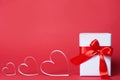 Gift box with hearts on red background. Top view, flat lay. St. Valentine`s day greetind concept