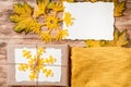 Gift box.kraft packaging.Mockup torn paper for your notes. Autumn bright dry leaves.Yellow knitted sweater.wooden background.flat Royalty Free Stock Photo