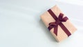 Gift box with kraft paper and a brown ribbon on a light blue background. Flat lay for father`s day concept Royalty Free Stock Photo