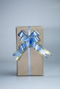 Gift box made of kraft paper with blue ribbon. Royalty Free Stock Photo