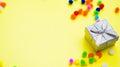 Gift box with multi-colored confetti on a yellow background. Royalty Free Stock Photo
