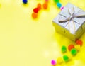 Gift box with multi-colored confetti on a yellow background. Royalty Free Stock Photo