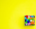 Gift box with multi-colored confetti on a yellow background. Royalty Free Stock Photo