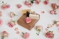 Gift box with natural homemade soap bars and rose flowers on white background. Holiday gift, opening present, top view. Royalty Free Stock Photo