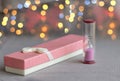 Gift box near the hourglass on a blurry background.