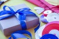 Gift box packaging on a yellow background. A lot of bright satin ribbons Royalty Free Stock Photo