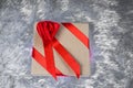 Gift box Packed in paper and tied with a red ribbon with a bow in the shape of a rose lies on the pillow fake fur. Royalty Free Stock Photo