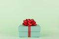 Gift Box, Pastel Green gift box with Red ribbon and bow on light green background Royalty Free Stock Photo