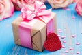 Gift box with pink bow ribbon and glitter hearts on blue spring background Royalty Free Stock Photo