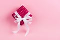 Gift box with pink ribbon on pink background Royalty Free Stock Photo