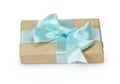 Gift box with present wrapped in kraft paper and blue bowknot bow. Isolated on white background, close up