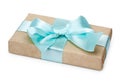 Gift box with present wrapped in kraft paper and blue bowknot bow. Isolated on white background, close up