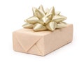 Gift box with present wrapped in kraft paper and with golden light beige bow isolated on the white background, gift ribbon bow Royalty Free Stock Photo