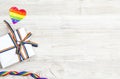 Gift box with rainbow LGBT ribbon on a light wooden background