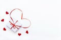 Gift box with a red bow and heart shaped ribbon with small felt hearts on a white background. Flat lay, top view. Valentine`s Day Royalty Free Stock Photo