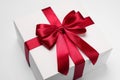 Gift box with red bow on light grey background, closeup Royalty Free Stock Photo