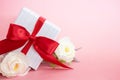 Gift box with red bow on a pink background . valentine `s or Mother`s or Women `s day celebration concept