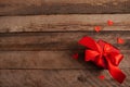 Gift box with red bow ribbon and paper hearts on wooden table for Valentines day. copy space Royalty Free Stock Photo