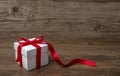 Gift box with red bow on rustic table, christmas or another celebration