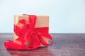 Gift box red bow on wood table. Copy space. Royalty Free Stock Photo