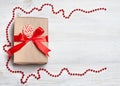 Gift box with red bow on wooden table. Christmas background with festive decoration. Place for your text. copyspace. top view, fla Royalty Free Stock Photo