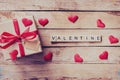 Gift box and red heart with wooden text Valentine on wood table Royalty Free Stock Photo