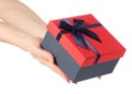 Gift box with a red lid and a blue bow in hand Royalty Free Stock Photo