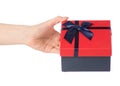 Gift box with a red lid and a blue bow in hand Royalty Free Stock Photo