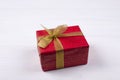 Gift. A box in a red package with a gold bow. On a white background. Christmas and Valentine\'s Day. Royalty Free Stock Photo