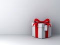 Gift box with red ribbon bow and blank tag over white wall background with shadow abstract Royalty Free Stock Photo