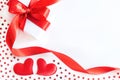 Gift box with red ribbon, decorative hearts and stars confetti on white background Royalty Free Stock Photo