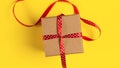 Gift box with red ribbon over yellow paper background Royalty Free Stock Photo