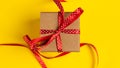 Gift box with red ribbon over yellow paper background Royalty Free Stock Photo