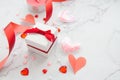 Gift box and paper hearts on white marble background for Valentines day