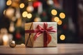 gift box with red ribbon on wooden table with blurred christmas tree background Royalty Free Stock Photo