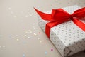 Gift box with red ribbonand confetti on gray background. Valentine mother day, sale, birthday concept