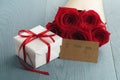 Gift box with red roses bouquet and i love you paper card on blue wood table Royalty Free Stock Photo
