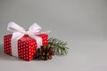 Gift box in red paper with white dots on grey background with copy space Royalty Free Stock Photo