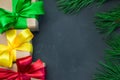 Gift box with ribbon bow and branch christmas tree on dark concrete background Royalty Free Stock Photo