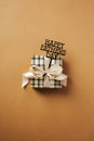 Gift box with ribbon bow and label Happy Fathers Day on brown background